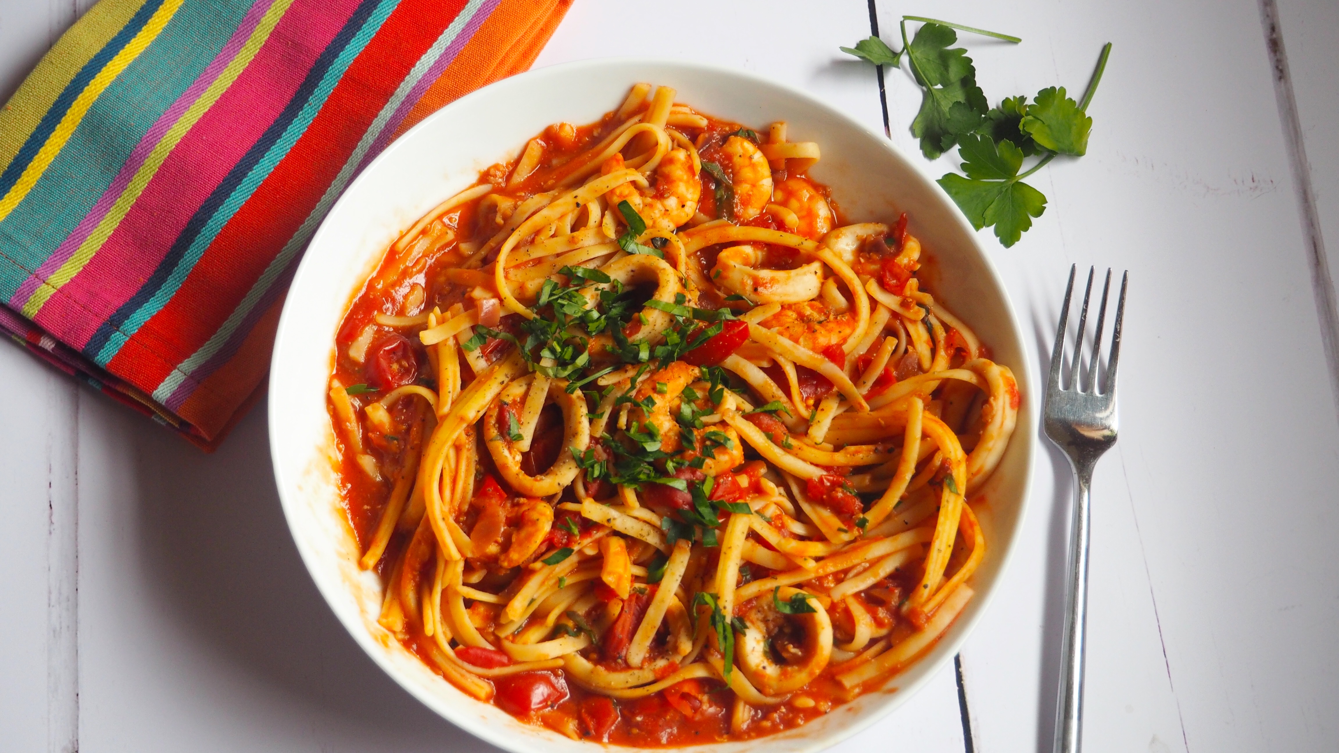 Spicy Seafood Pasta | This Spicy Seafood Pasta is packed full of flavour with juicy prawns and calamari in a rich tomato sauce with a kick of chilli and chopped basil. Gluten and dairy free too.